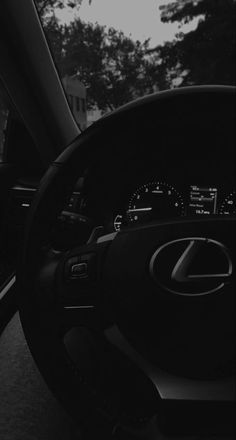 the interior of a car with dashboard lights and steering wheel controls, in black and white