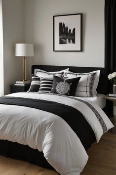 a bed with black and white comforters in a bedroom next to a window,