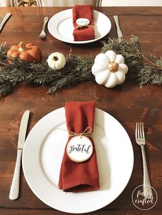 a place setting with napkins, silverware and pumpkins