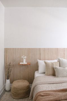 a bed sitting in a bedroom next to a wall with stripes painted on it's side