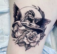 a black and white photo of a tattoo on the thigh