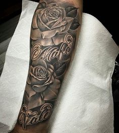 a man's arm with roses and the word tattoo on it, in black and grey