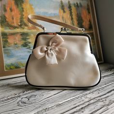 Vintage Satin light beige handbag with bow-knot on the front and black cants . Evening clutch purse Disco 60's 70's style. For wedding, bachelor, bachelorette party. Vintage condition. One handbag with slightly yellowed traces of time on the fabric. Please, click to  images and video to see details. Dimensions:                                       10 x 2.5 x 7 inch / 25 x 6 x 18 cm Handle : 12 inch / 30 cm  Item will be shipped in 1-2 days after payment will be clear. All items are very safe pa Beige Handbag, Beige Handbags, Satin Clutch, Clutch Purse Evening, Movie Props, Evening Clutch, White Satin, 70s Fashion, Clutch Purse