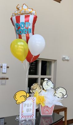 some balloons and popcorn bags on a table