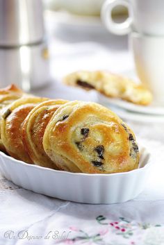 blueberry danish rolls in a white dish on a table