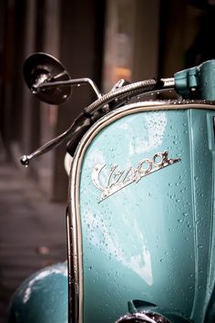 a blue scooter parked on the street next to a building