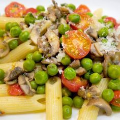 pasta with peas and tomatoes on a white plate