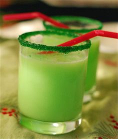 two glasses filled with green liquid on top of a table