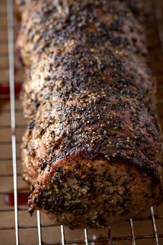 a meatloaf is sitting on a wire rack with ketchup and seasoning