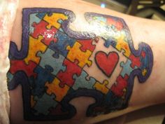 a person with a tattoo on their arm has a piece of puzzle in the shape of a heart