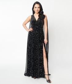 Become the center of the universe with this 1960s inspired gown set in a gorgeous black velvet twinkling with silver constellations throughout. Outfitted with a V neckline and slit for an extra sultry effect. Complete with a cape for extra dramatics.Available in sizes XS-5X while supplies last. The Center Of The Universe, Center Of The Universe, Uv Clothing, 1960s Outfits, 1960s Inspired, Cape Gown, Plus Size Prom, Prom Dresses Sleeveless, Timeless Classic Style