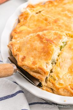 a close up of a pie in a pan on a table with a wooden spatula