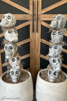 two cement pots with skulls stacked on top of each other