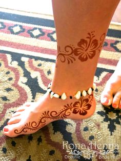 a woman's feet with henna tattoos on them