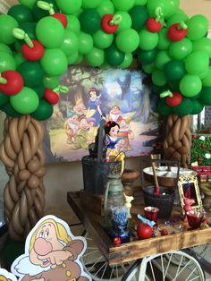 the balloon arch has been decorated with snow white and seven dwarfs, as well as other decorations