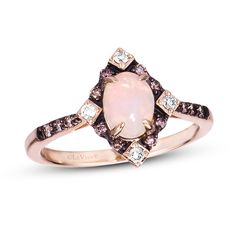 a pink opal and diamond ring on a white background