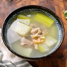 a bowl filled with soup on top of a wooden table