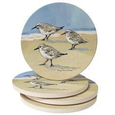 three coasters with birds painted on them