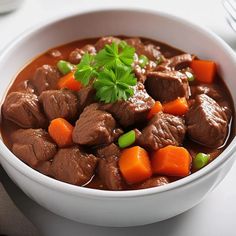 a white bowl filled with beef and carrots