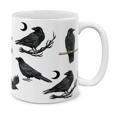 a white coffee mug with black crows on it's sides and the moon in the background