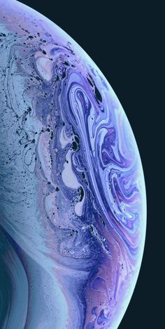 an iphone with purple and blue swirls on the screen, next to a black background