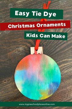 an ornament hanging from a wooden table with text overlay that reads easy tie dye christmas ornaments kids can make