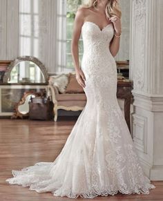 a beautiful blonde woman in a white wedding dress posing for the camera with her hand on her hip