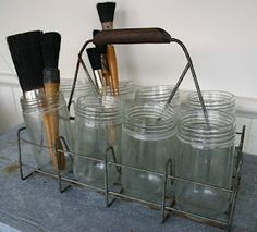 there are many jars with brushes in them