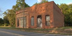 an old brick building sitting on the side of a road