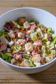 a white bowl filled with salad on top of a wooden table