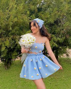 a woman in a blue dress holding flowers