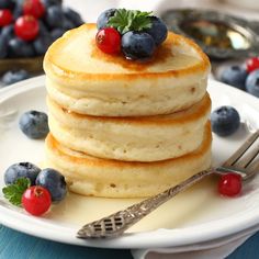 stack of pancakes with blueberries and raspberries on top