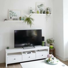 a flat screen tv sitting on top of a white entertainment center in a living room