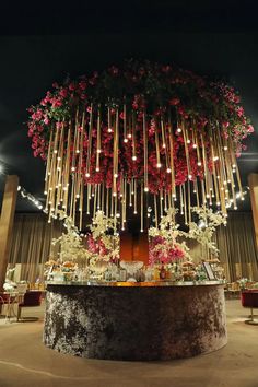 a table with flowers and candles on it at a wedding reception in the middle of a room