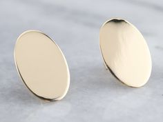 Beautifully polished and simple-as-can-be in design. These gleaming yellow gold oval studs were adapted from a pair of antique cufflinks and given a bright polish. Wear these minimalist studs everyday with a suit-dress or jeans! Market Square Jewelers works with one of the finest hand engravers in the northeast. With over 30 years of experience, our engraver hand carves lettering, monograms, crests, or patterns in period-specific styles. Choose from our many monogram options shown in the listing Minimalist 14k Gold Oval Earrings, Minimalist Oval 14k Gold Earrings, Gold Oval Cabochon Earrings With Polished Finish, Classic Yellow Gold Oval Cabochon Earrings, Modern Gold Round Cufflinks, Minimalist Oval Link Earrings For Formal Occasions, Classic Gold Oval Cufflinks, Classic Oval Yellow Gold Cufflinks, Classic Yellow Gold Oval Cufflinks