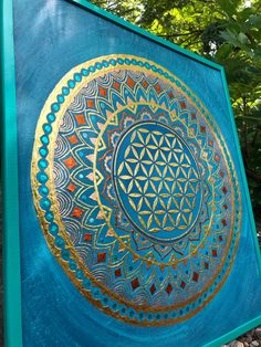 a blue and gold painting on the side of a building with trees in the background