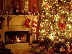 a christmas tree with stockings hanging from it's sides in front of a fireplace