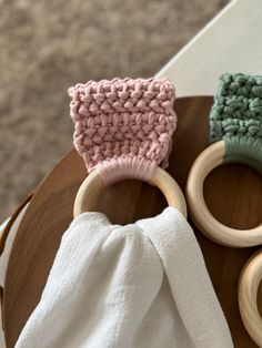 two wooden rings with crochet on them sitting on top of a table next to a white towel