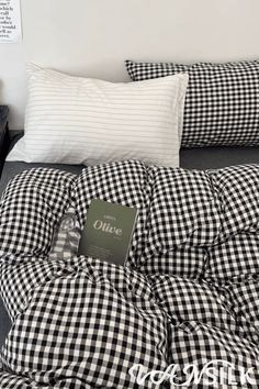 a black and white checkered comforter on top of a bed next to pillows