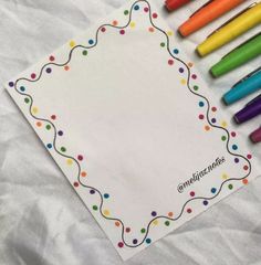 colored crayons sitting on top of a white paper