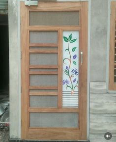 the front door is decorated with flowers and leaves on it's glass paneling