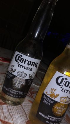 two bottles of beer sitting on top of a table