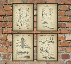 four framed drawings of musical instruments on a brick wall