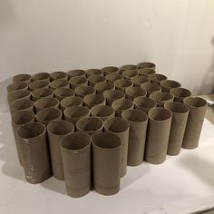 a bunch of brown paper cups sitting on top of a white table next to each other