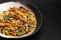 a bowl filled with noodles and vegetables on top of a table