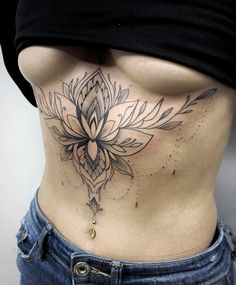 a woman's stomach with a tattoo design on the bottom and lower part of her body