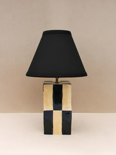 a lamp that is on top of a table with a black and white striped shade