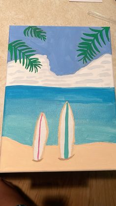 two surfboards on the beach with palm trees