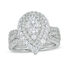 a white gold ring set with diamonds on the band and an oval shaped diamond in the center