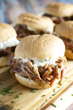 a pulled pork sandwich on a wooden cutting board